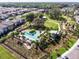 Aerial view of a community pool and playground surrounded by lush landscaping and modern homes at 3057 Riders Pass, Odessa, FL 33556