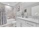Bright bathroom featuring tiled shower/tub combo, decorative mirror, and white vanity providing elegance and functionality at 3057 Riders Pass, Odessa, FL 33556