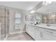 Elegant bathroom with double vanity, quartz countertop, and glass shower at 3057 Riders Pass, Odessa, FL 33556