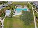 Aerial shot of a community pool featuring lounge chairs, splash pad, playground, and picnic area nestled in a neighborhood at 3057 Riders Pass, Odessa, FL 33556