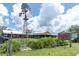 Charming commercial property featuring a windmill, sign, and gazebo, set against a backdrop of a clear sky and lush greenery at 3057 Riders Pass, Odessa, FL 33556