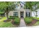 Charming two-story home featuring a balcony, black shutters, and a well-manicured front yard with lush landscaping at 3057 Riders Pass, Odessa, FL 33556