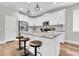 Modern kitchen featuring white cabinets, stainless steel appliances, and a spacious center island with seating at 3057 Riders Pass, Odessa, FL 33556