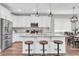 Modern kitchen with white cabinetry, stainless steel appliances, and a center island with bar stool seating at 3057 Riders Pass, Odessa, FL 33556