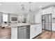 Bright, open-concept kitchen features stainless steel appliances, granite countertops, and seamless flow into the living area at 3057 Riders Pass, Odessa, FL 33556