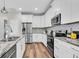 Bright kitchen with white cabinets, stainless steel appliances, and a granite countertop at 3057 Riders Pass, Odessa, FL 33556