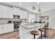 Modern kitchen featuring white cabinetry, stainless steel appliances, and a center island with bar stool seating at 3057 Riders Pass, Odessa, FL 33556