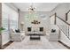 Bright living room featuring a modern light fixture, a comfortable seating arrangement, and stylish decor at 3057 Riders Pass, Odessa, FL 33556