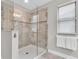 Modern walk-in shower with glass door and neutral tile surround at 3057 Riders Pass, Odessa, FL 33556