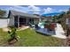 Lush backyard with outdoor lounge area, dining table, and swimming pool at 3074 Cara Ct, Palm Harbor, FL 34684