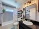 Stylish bathroom featuring a modern vanity, decorative wallpaper, and a tub-shower with decorative shower curtain at 3074 Cara Ct, Palm Harbor, FL 34684