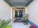 Charming entryway featuring a blue door, decorative plants, and neutral tones for a welcoming appeal at 3074 Cara Ct, Palm Harbor, FL 34684