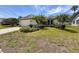 Well-maintained single-story home featuring a landscaped front yard with vibrant plants and a two-car garage at 3074 Cara Ct, Palm Harbor, FL 34684