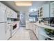 Well-lit kitchen featuring white cabinets, modern appliances, and tiled backsplash for a clean look at 3074 Cara Ct, Palm Harbor, FL 34684