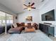 Bright living room with a brown sectional, decorative rug, and access to the screened patio at 3074 Cara Ct, Palm Harbor, FL 34684