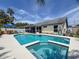 Inviting backyard featuring a private pool, spa, screened-in lanai, and outdoor seating area at 3074 Cara Ct, Palm Harbor, FL 34684