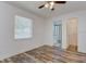 Bright bedroom features wood-look flooring, a ceiling fan, a window, and ensuite bathroom access at 37733 14Th Ave, Zephyrhills, FL 33542