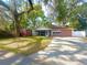 Home with mature trees, large front yard, and a detached storage shed at 37733 14Th Ave, Zephyrhills, FL 33542