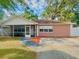 Charming home with screened front porch, manicured lawn, and mature landscaping at 37733 14Th Ave, Zephyrhills, FL 33542