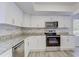 Modern kitchen features white cabinets, stainless steel appliances, and a stylish backsplash at 37733 14Th Ave, Zephyrhills, FL 33542