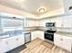 Modern kitchen features white cabinets, stainless steel appliances, and granite counters at 37733 14Th Ave, Zephyrhills, FL 33542