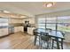 Modern kitchen features white cabinets, stainless steel appliances, and a dining table with chairs at 37733 14Th Ave, Zephyrhills, FL 33542
