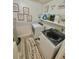 Laundry room with a front-load washer, dryer, decorative signs, and shelving at 37733 14Th Ave, Zephyrhills, FL 33542