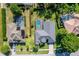 Stunning aerial view of a home featuring a screened pool, well-maintained lawn, mature trees and a driveway at 4044 Chesterfield Dr, Spring Hill, FL 34609
