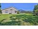 A spacious backyard features a screened-in pool, lush green grass, and a privacy fence for outdoor enjoyment at 4044 Chesterfield Dr, Spring Hill, FL 34609
