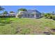 A large backyard features a screened-in pool, lush grass, and private landscaping, offering plenty of outdoor space at 4044 Chesterfield Dr, Spring Hill, FL 34609