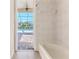 Bathroom with tiled shower-tub combination and view of the pool at 4044 Chesterfield Dr, Spring Hill, FL 34609
