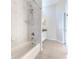Bathroom with tiled shower-tub combination and white tile walls at 4044 Chesterfield Dr, Spring Hill, FL 34609