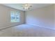 Bright bedroom featuring neutral carpeting, a ceiling fan, and a window with a view of the outdoors at 4044 Chesterfield Dr, Spring Hill, FL 34609