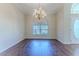 Bright dining room features hardwood floors, arched window, and elegant chandelier fixture at 4044 Chesterfield Dr, Spring Hill, FL 34609