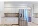 Spacious kitchen featuring stainless steel fridge, white cabinetry, granite countertops, and tile backsplash at 4044 Chesterfield Dr, Spring Hill, FL 34609
