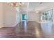 Spacious living room featuring hardwood floors, neutral paint, and access to the outdoor pool area at 4044 Chesterfield Dr, Spring Hill, FL 34609
