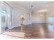 Open concept living room with hardwood floors, neutral paint, access to kitchen and view of backyard at 4044 Chesterfield Dr, Spring Hill, FL 34609