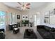 Staged living room featuring a ceiling fan, comfortable seating, and sliding glass doors to the outdoor area at 4044 Chesterfield Dr, Spring Hill, FL 34609