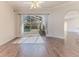 Bright living room features hardwood floors, neutral paint, ceiling fan, and backyard pool view at 4044 Chesterfield Dr, Spring Hill, FL 34609