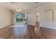 Bright living room features hardwood floors, neutral paint, ceiling fan, and backyard pool view at 4044 Chesterfield Dr, Spring Hill, FL 34609