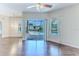 Open-concept living room with hardwood floors and a view of the outdoor pool area through sliding glass doors at 4044 Chesterfield Dr, Spring Hill, FL 34609