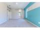 Large bedroom featuring turquoise accent wall with arched windows, carpeted flooring and white trim throughout the home at 4044 Chesterfield Dr, Spring Hill, FL 34609