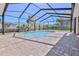 A screened-in pool area boasts brick pavers and a clear blue pool, ideal for relaxing and enjoying the outdoors at 4044 Chesterfield Dr, Spring Hill, FL 34609