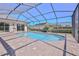 A screened-in pool area has brick pavers, a pool, and a house, offering a relaxing outdoor space at 4044 Chesterfield Dr, Spring Hill, FL 34609