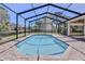 The screened-in pool area, with brick pavers and a serene pool, offers a private and calming retreat at 4044 Chesterfield Dr, Spring Hill, FL 34609