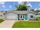 Charming single-story home features a well-manicured lawn and a bright teal front door at 4315 Oakland Dr, New Port Richey, FL 34653