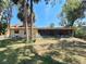 Spacious backyard featuring a screened lanai, lush lawn, mature trees, and ample seating areas at 4328 Marine Pkwy, New Port Richey, FL 34652