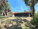 Backyard with a spacious lawn, partially shaded, featuring a screened-in patio for relaxing and entertaining at 4328 Marine Pkwy, New Port Richey, FL 34652