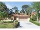 Charming single-story home featuring a well-manicured lawn, mature trees, and a two-car garage at 4328 Marine Pkwy, New Port Richey, FL 34652