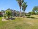 Manicured backyard with palm trees, landscaping, and screened-in pool area at 4423 Gevalia Dr, Brooksville, FL 34604